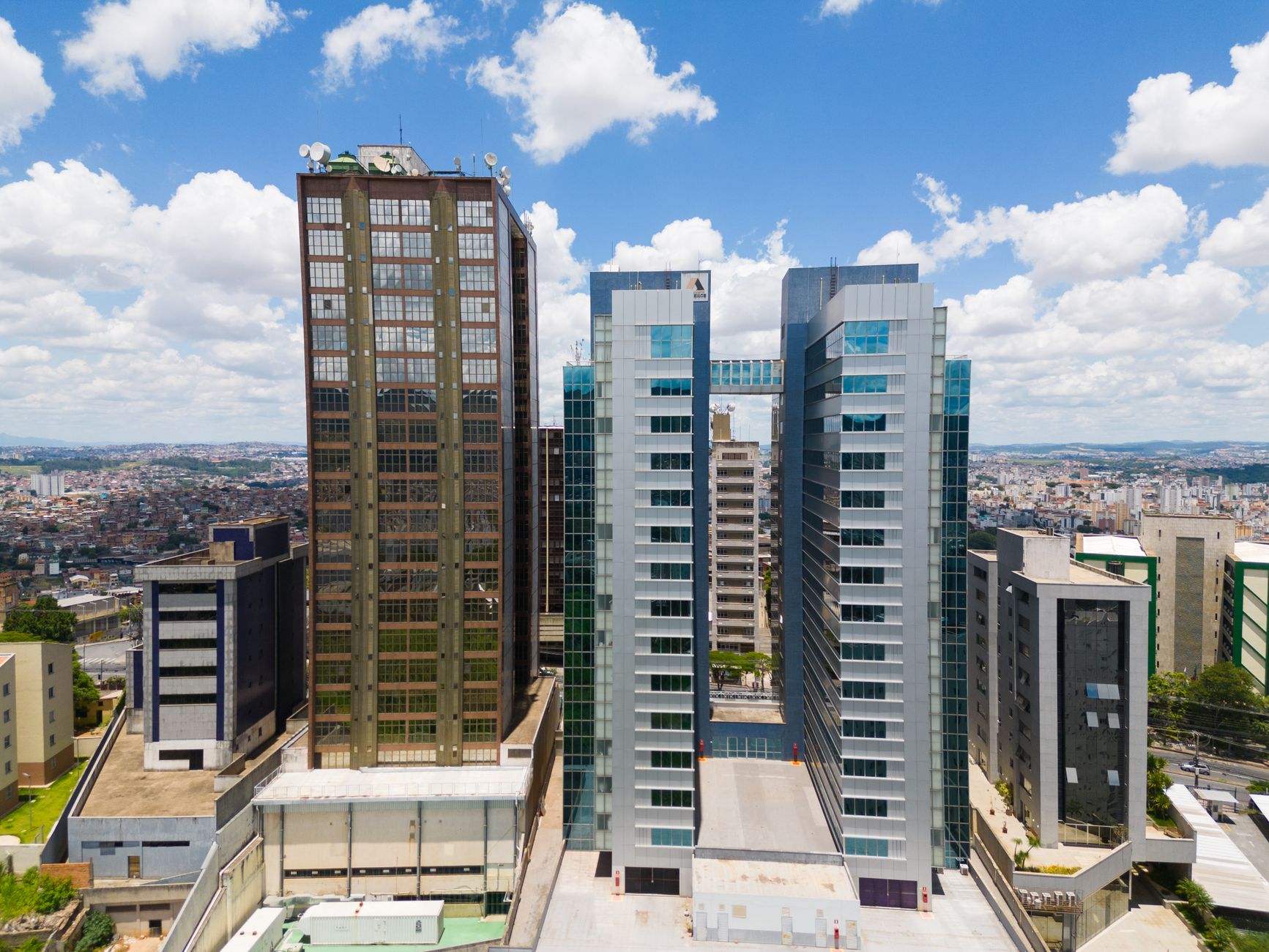 Fachada de edifício corporativo moderno com estrutura de vidro espelhado refletindo o céu.
