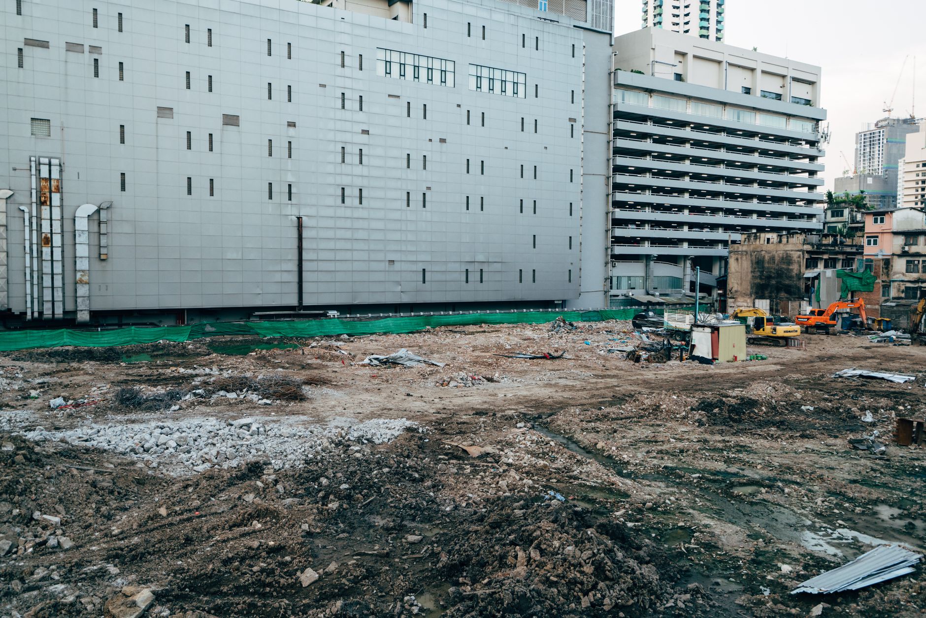 Estrutura de prédio em construção com guindaste ao fundo.