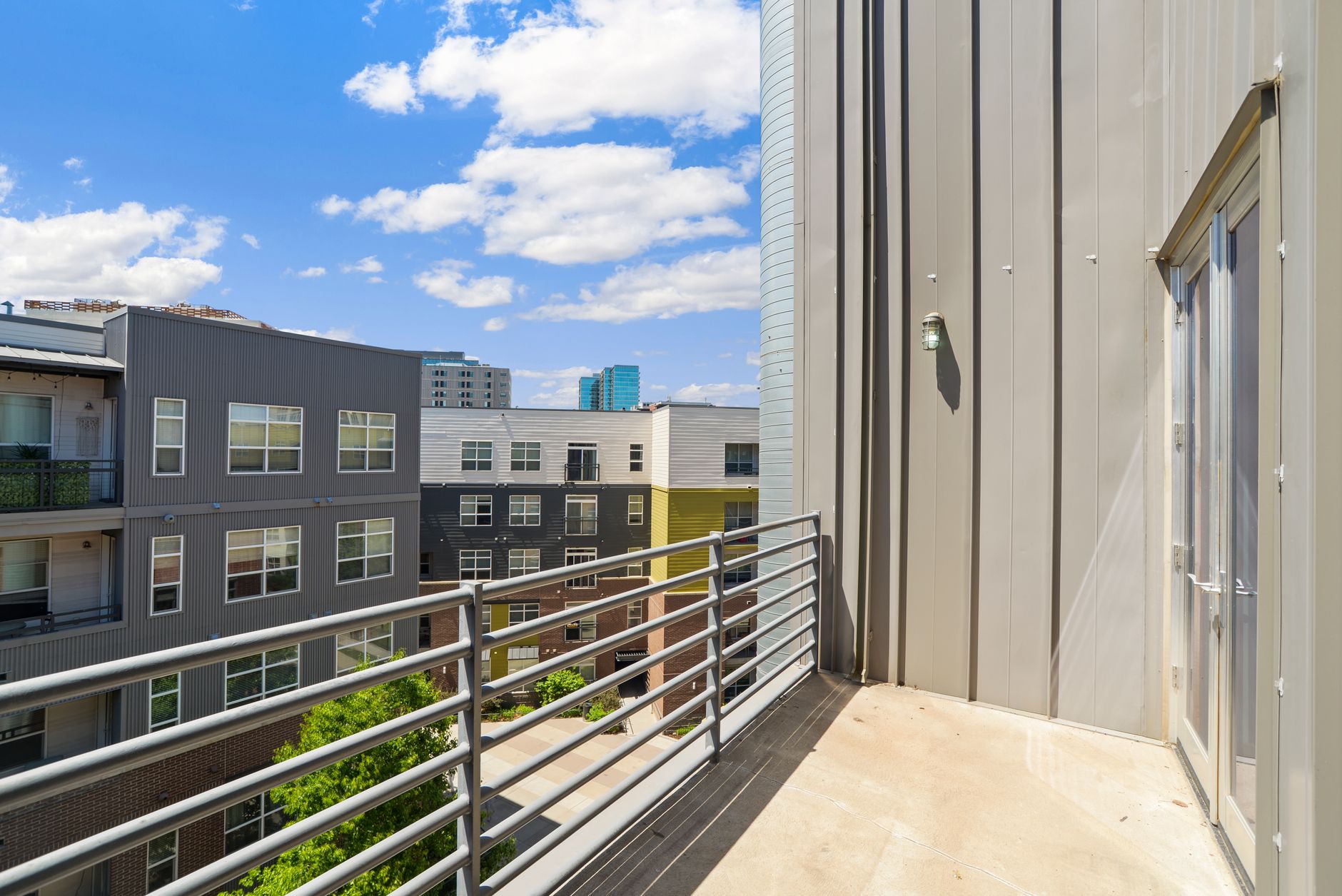 Varanda de apartamento moderno com vista panorâmica para o horizonte urbano.