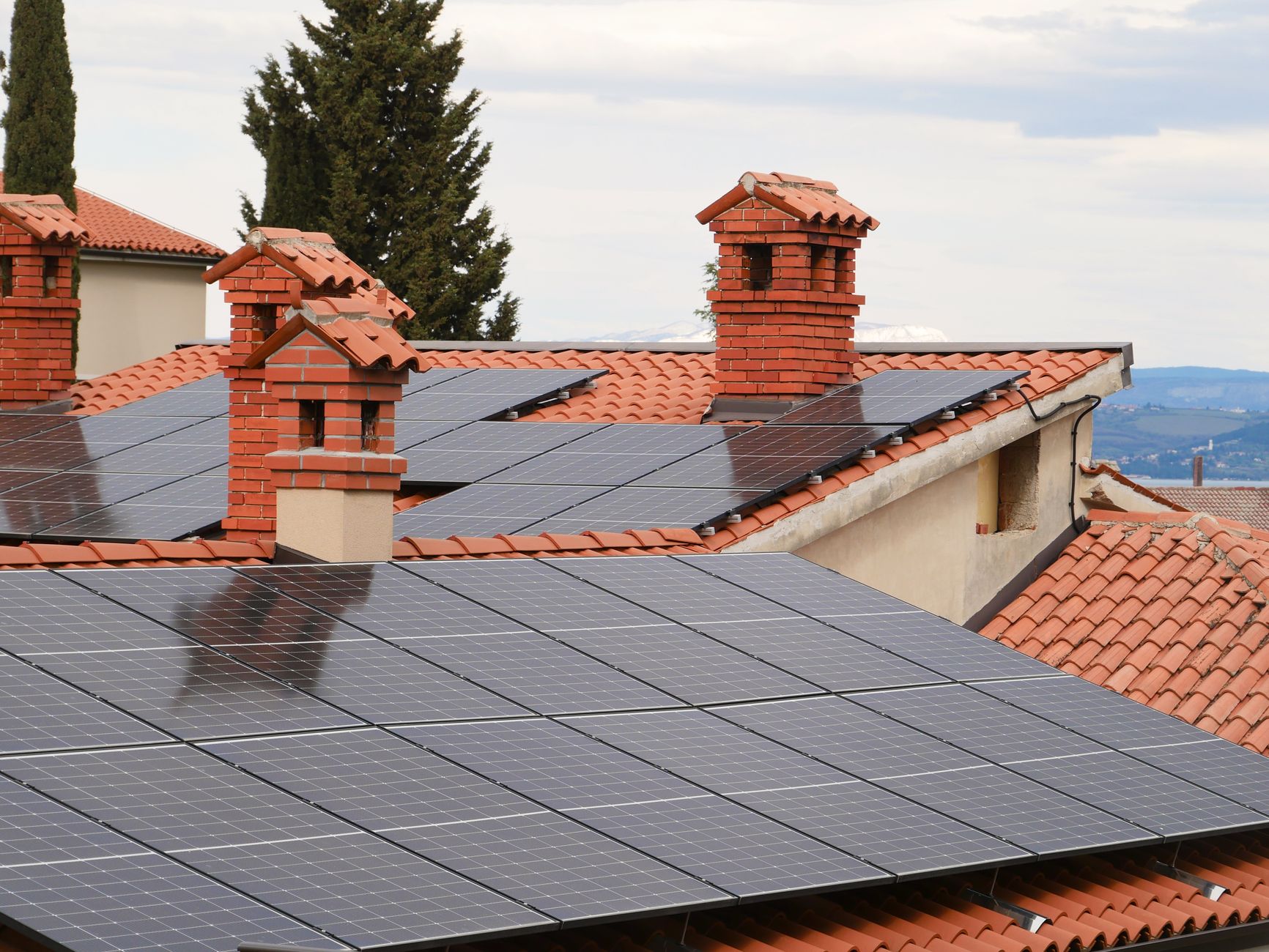 Close-up de placas solares fotovoltaicas instaladas de forma organizada sobre o telhado de uma residência.